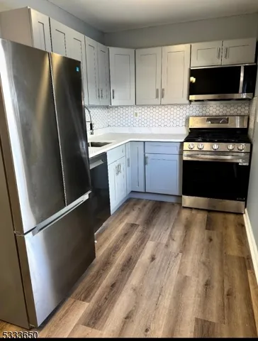 a kitchen with stainless steel appliances a refrigerator stove and microwave