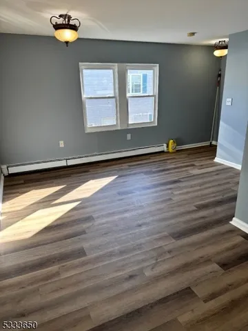 a view of empty room with window and wooden floor