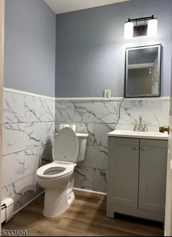 a bathroom with a granite countertop toilet sink and mirror