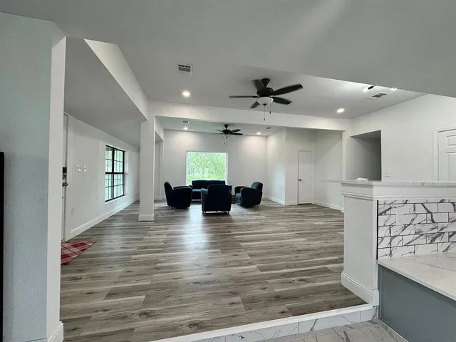 a large kitchen with a large counter top stainless steel appliances and cabinets