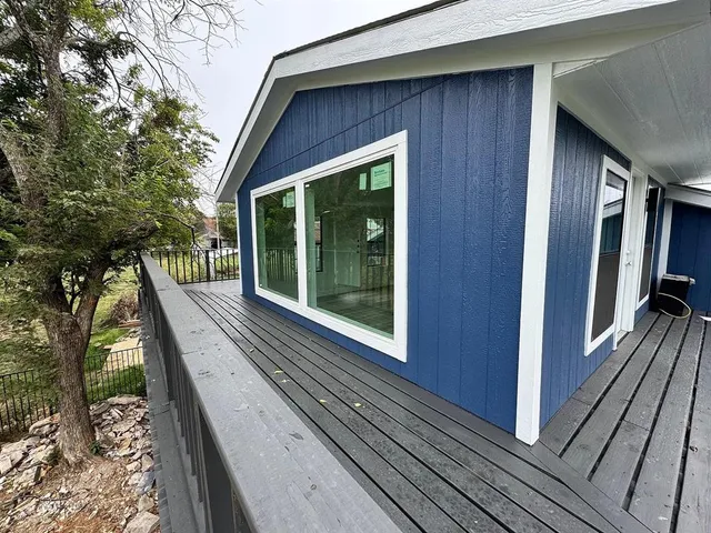 a balcony with wooden floor and trees in the back