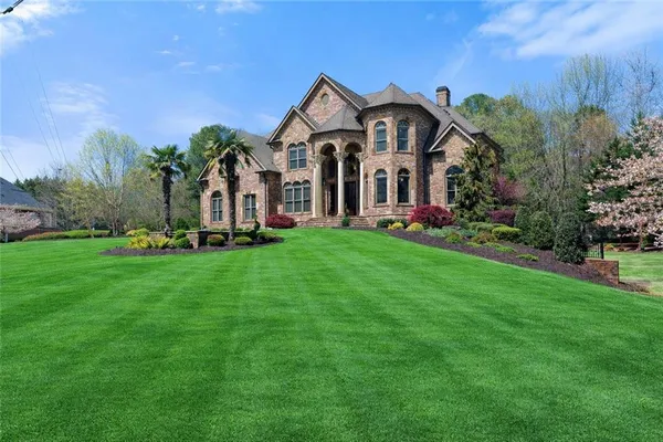 a front view of a house with a garden and plants