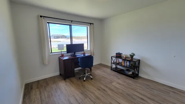 a view of a workspace with furniture and a window