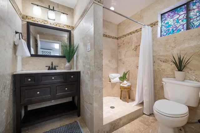 a bathroom with a sink a toilet and shower