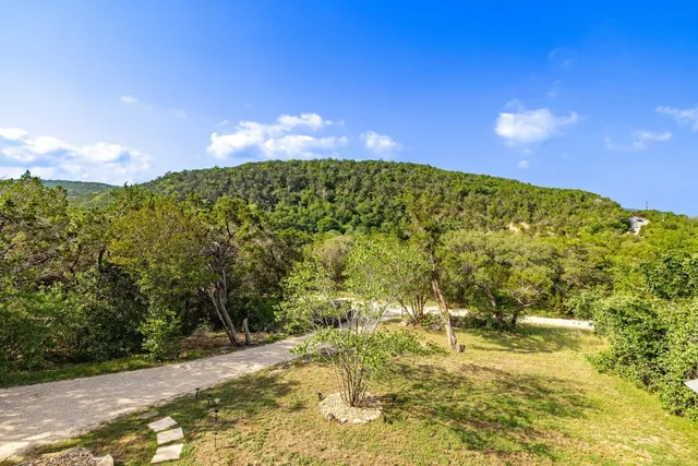 a view of a large yard with green space and a building in the background