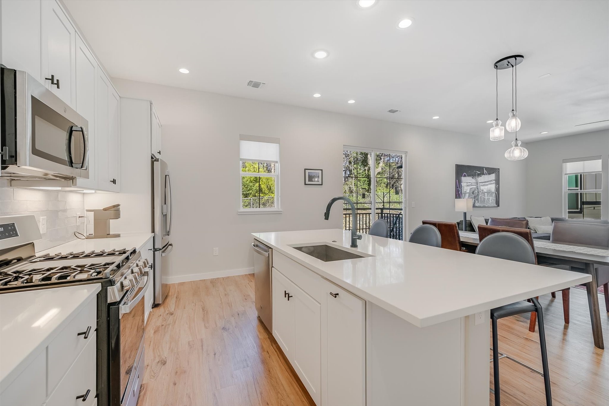 3809 Valley View Road, Unit 7 Austin, TX 78704 - Photo 10 of 21 Kitchen featuring pendant lighting, sink, a kitchen island with sink, white cabinetry, and stainless steel appliances