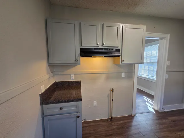 a kitchen with granite countertop white cabinets and black appliances