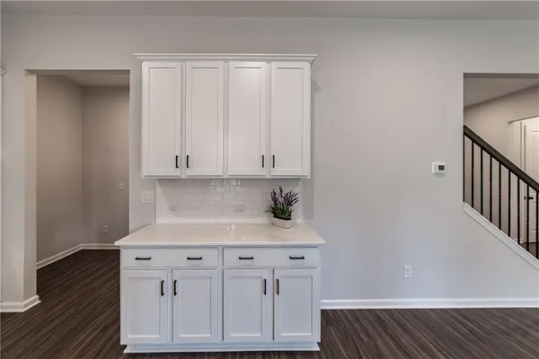 a view of a hallway with wooden floor and closet area
