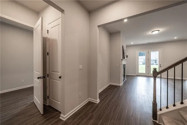 a kitchen with stainless steel appliances granite countertop a refrigerator a sink dishwasher a stove and white cabinets with wooden floor