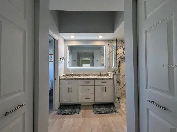a bathroom with granite countertop a sink and a mirror
