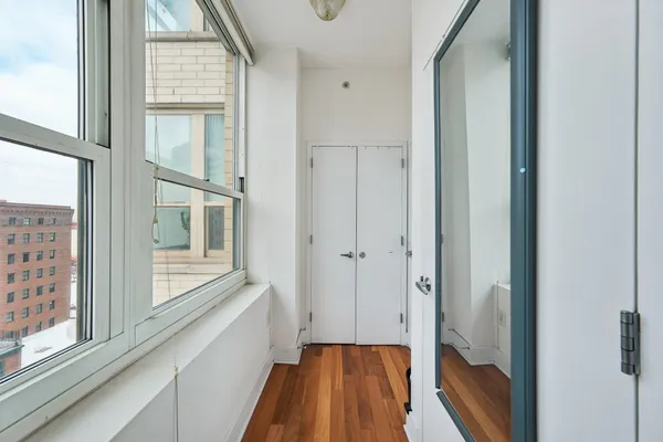 a view of a hallway with wooden floor and staircase