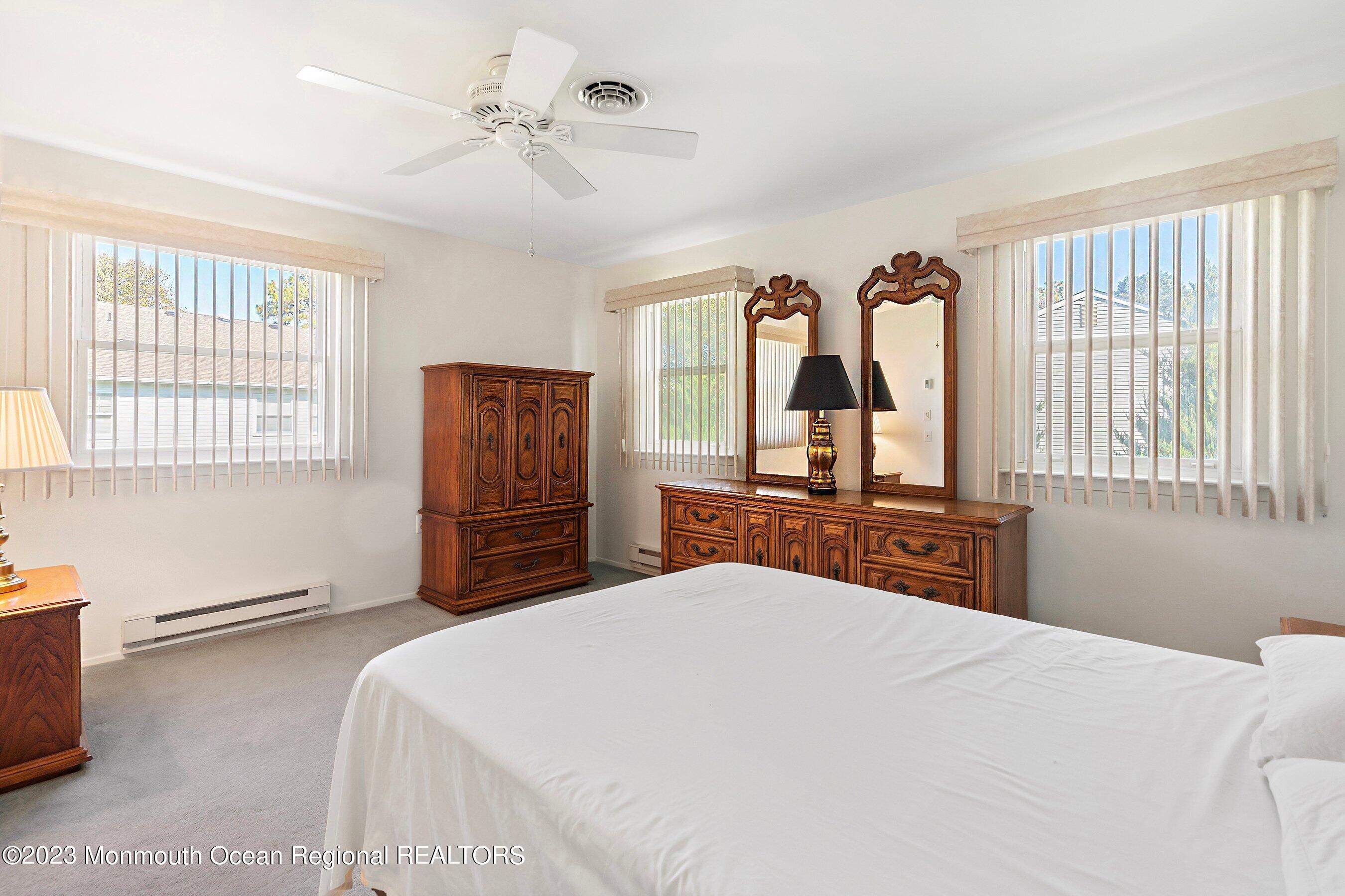 9 Amherst Road, Unit 64 Whiting, NJ 08759 - Photo 17 of 30 a bedroom with a large bed and a chandelier