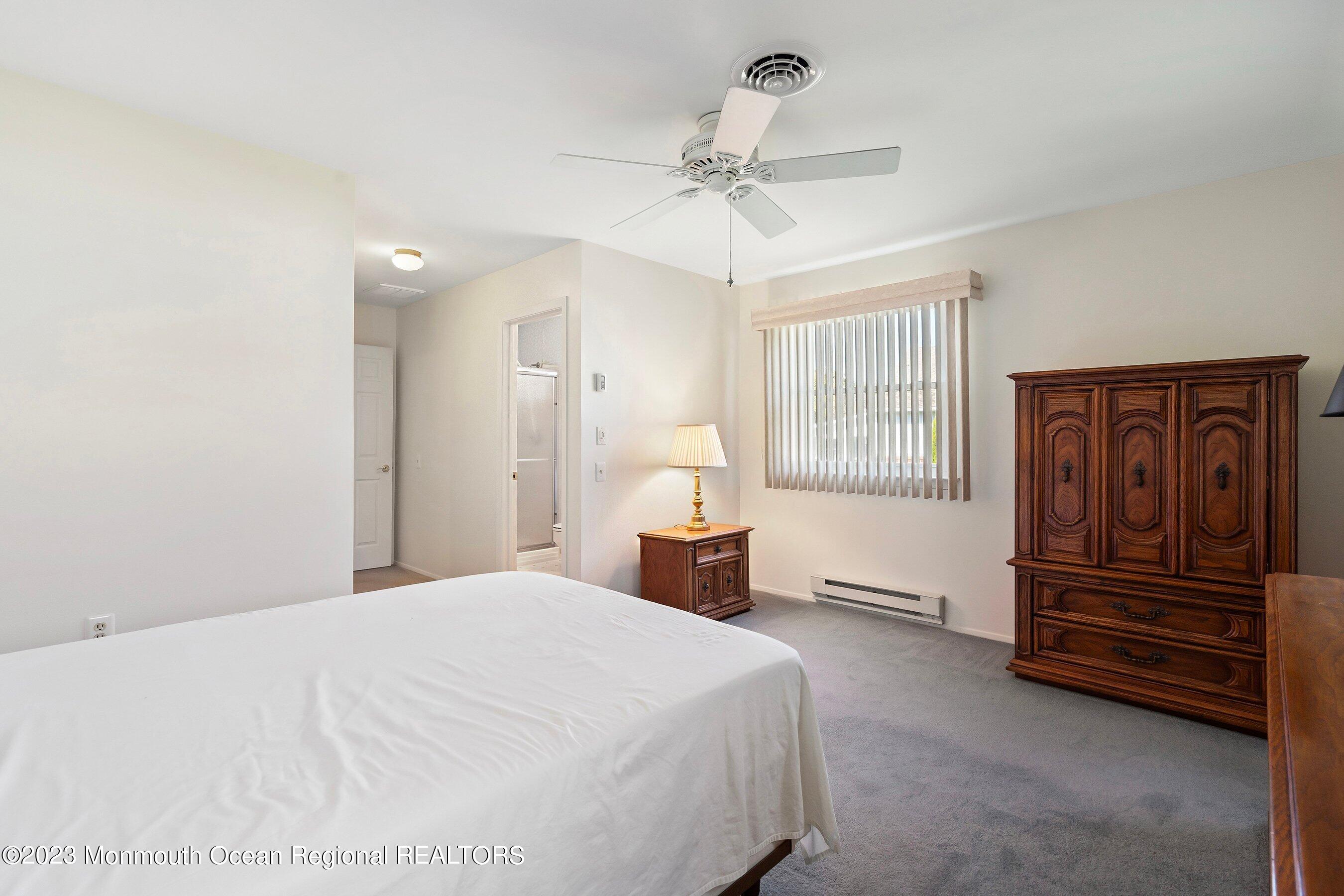 9 Amherst Road, Unit 64 Whiting, NJ 08759 - Photo 18 of 30 a spacious bedroom with a bed and a chandelier