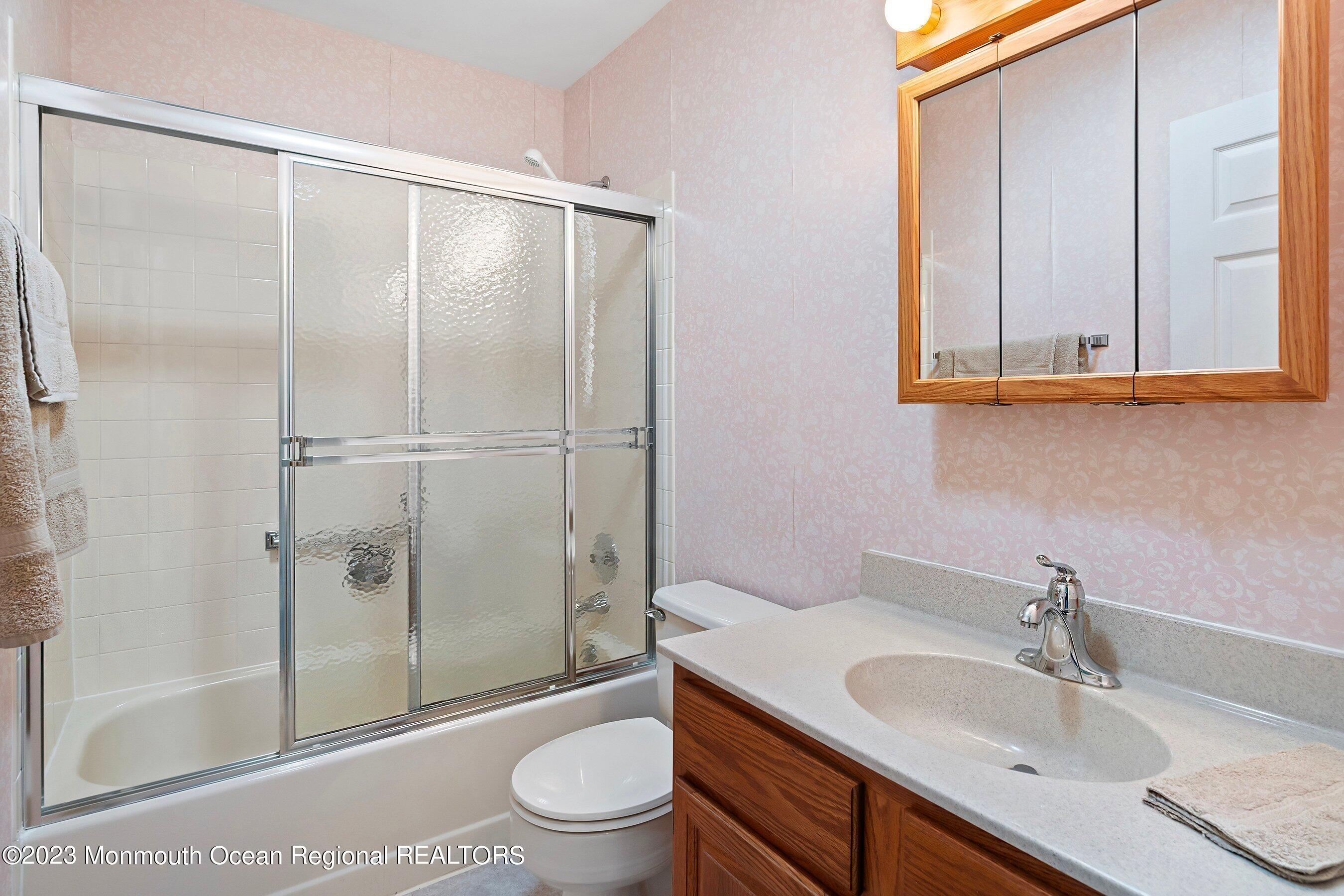 9 Amherst Road, Unit 64 Whiting, NJ 08759 - Photo 22 of 30 a bathroom with a granite countertop sink toilet and shower