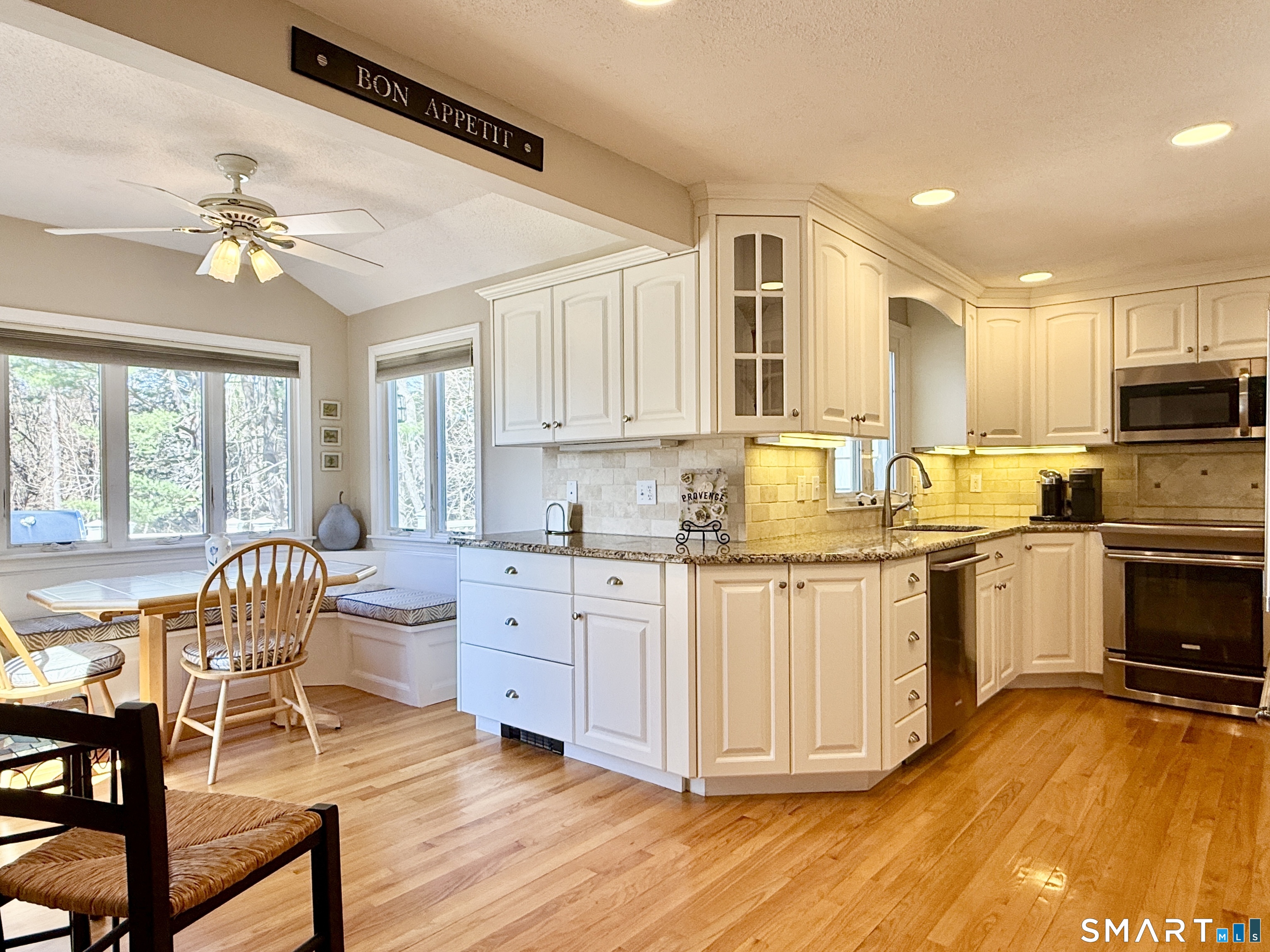 17 Sunnybrook Drive Avon, CT 06001 - Photo 4 of 40 a kitchen with granite countertop a stove top oven cabinets a dining table and chairs