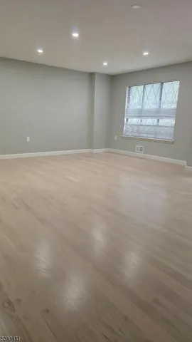 an empty room with a windows and chandelier