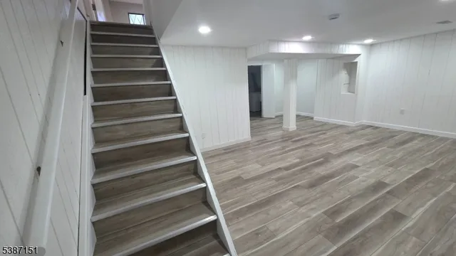 a view of an empty room with stairs and a ceiling fan