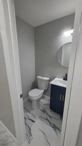 a white toilet sitting next to a sink and vanity