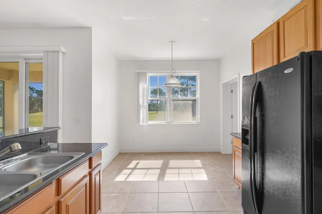 a kitchen with stainless steel appliances granite countertop a refrigerator a sink a stove and island