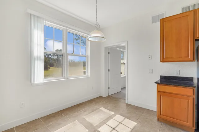 a view of an empty room with window and cabinet