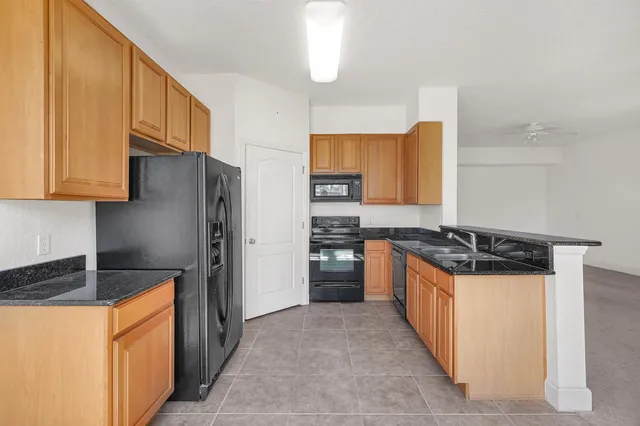a kitchen with stainless steel appliances granite countertop a stove a refrigerator a sink and dishwasher