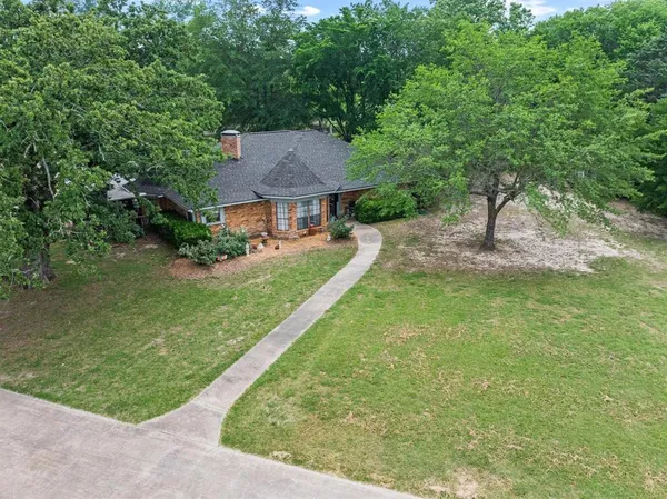 a view of a big house with a big yard and large tree