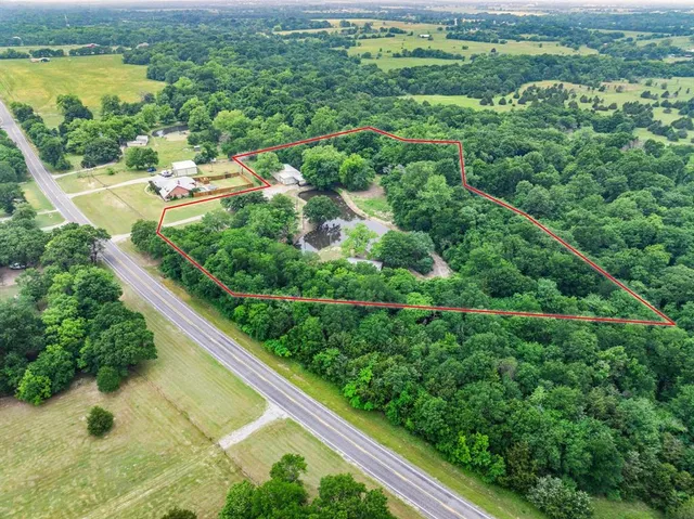 an aerial view of residential houses with outdoor space and trees