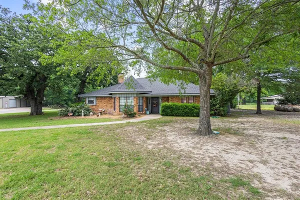 a view of a house with a yard and tree s
