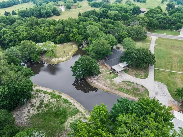 an aerial view of a house with a yard and lake view
