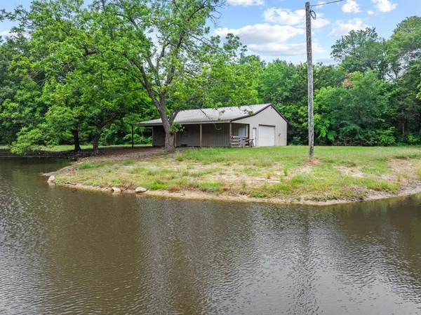a view of a house with a yard and a pond