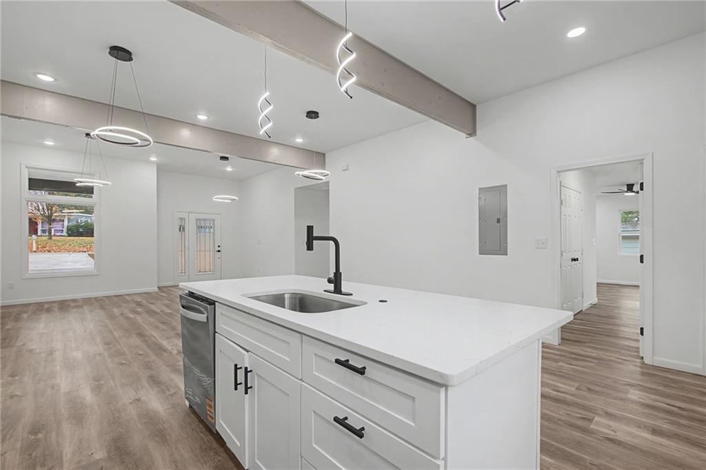 1667 Thornton Place Southwest Atlanta, GA 30315 - Photo 14 of 41 a kitchen with a sink dishwasher and white cabinets with wooden floor