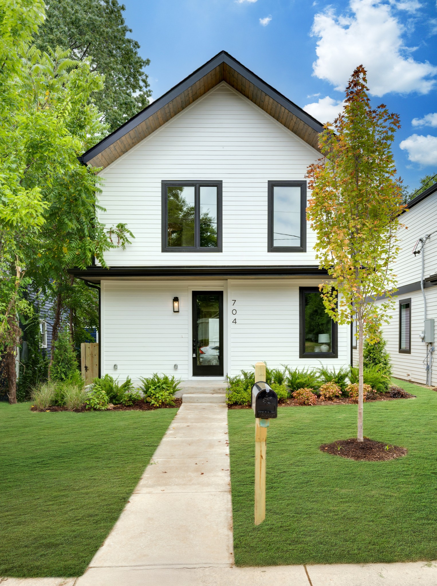 a front view of a house with a yard and trees