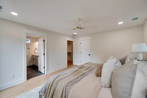 a bedroom with a large bed and a chandelier