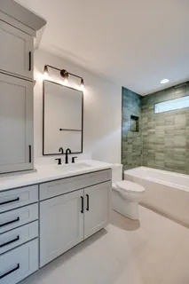 a bathroom with a toilet a sink a mirror and bathtub