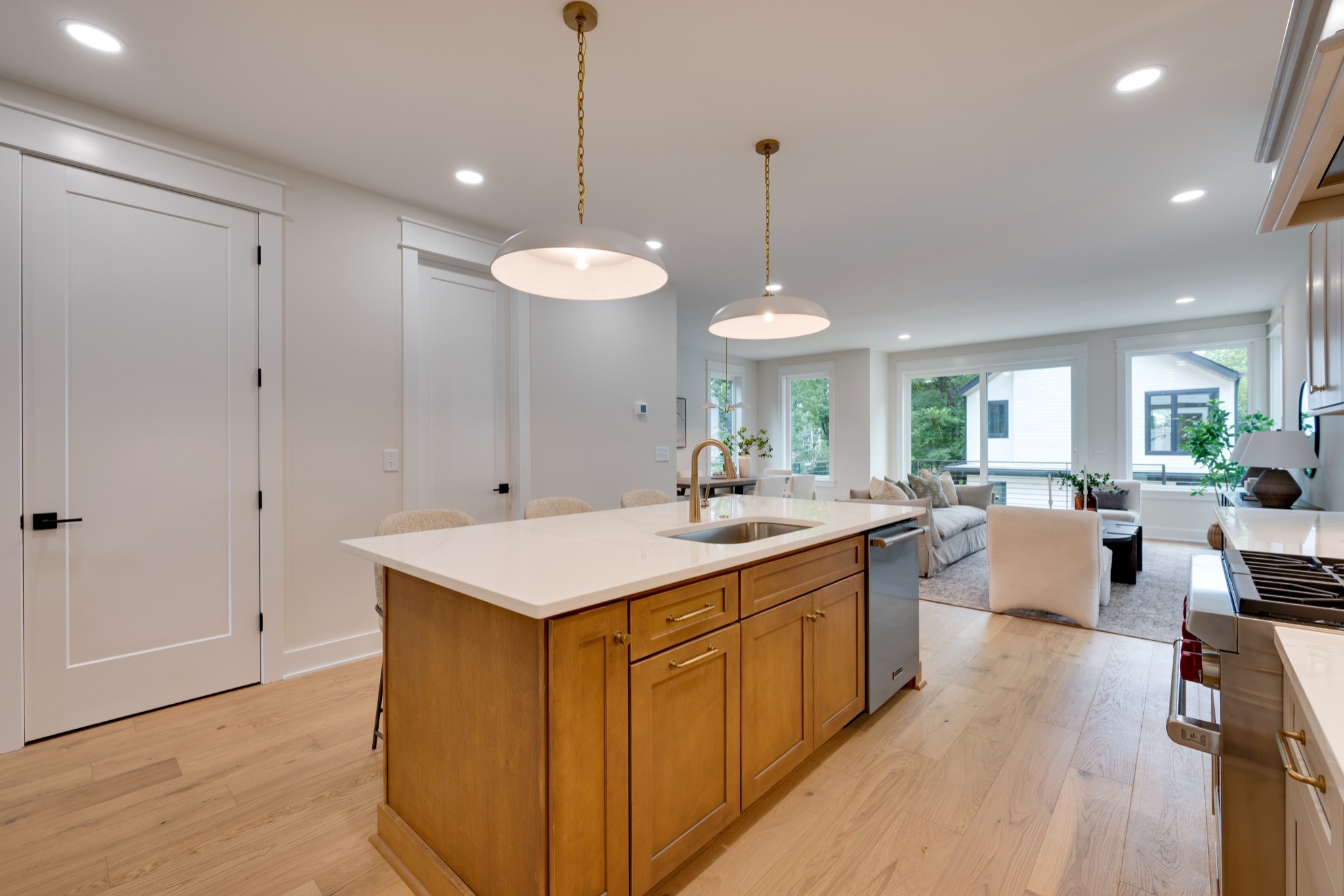 704 Stockell Street Nashville, TN 37207 - Photo 6 of 32 a large kitchen with kitchen island a sink a center island a wooden floor and a chandelier