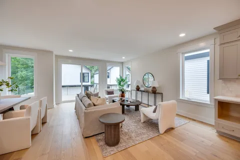 a living room with fireplace furniture and a large window