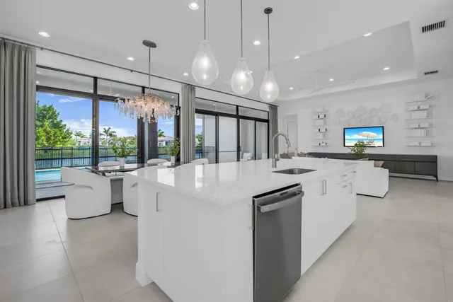a kitchen with stainless steel appliances a dining table chairs and couches