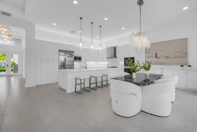 a kitchen with kitchen island stainless steel appliances a table and chairs in it