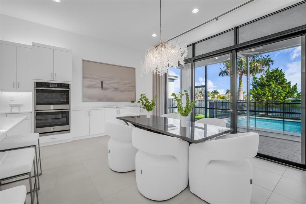 11242 Gln Orch Lane Boynton Beach, FL 33473 - Photo 16 of 55 a kitchen with stainless steel appliances kitchen island granite countertop a refrigerator and a sink