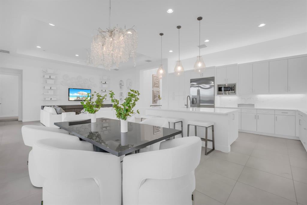 11242 Gln Orch Lane Boynton Beach, FL 33473 - Photo 17 of 55 a kitchen with kitchen island stainless steel appliances a table and chairs in it