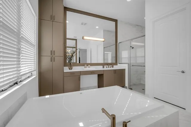 a spacious bathroom with a bathtub sink and mirror