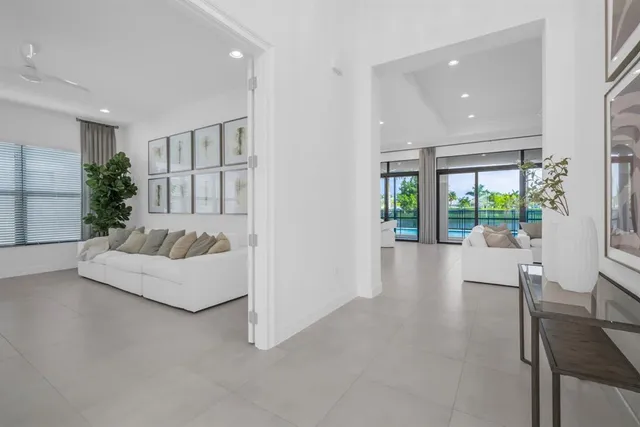 a living room with furniture a large window and white walls