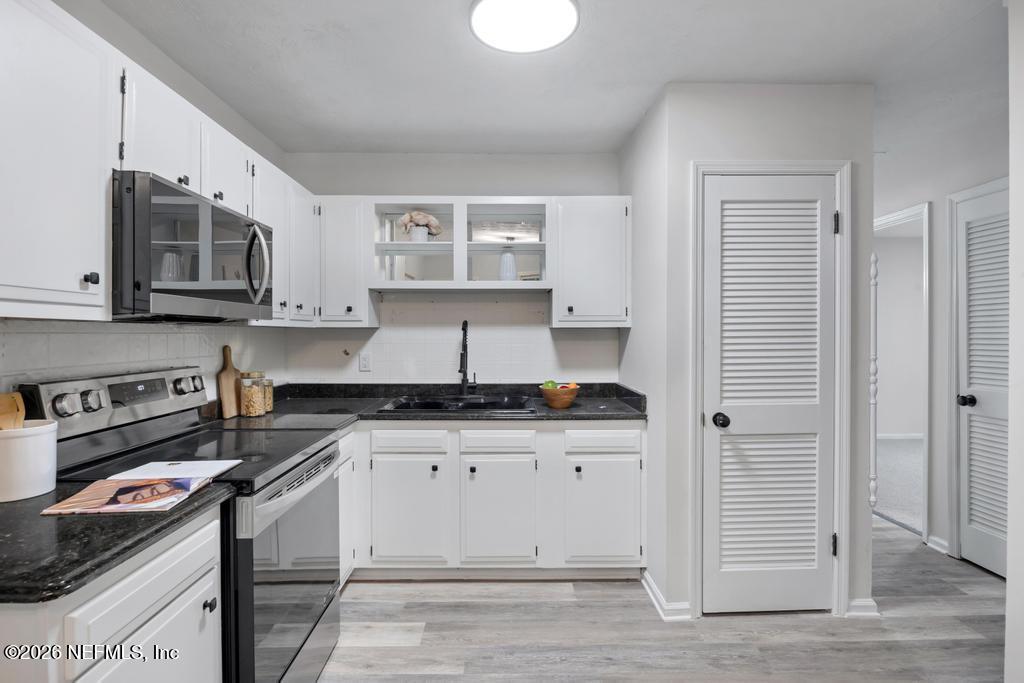 4634 Whimbrel Lane Fernandina Beach, FL 32034 - Photo 8 of 42 a kitchen with stainless steel appliances granite countertop a stove and a white cabinets