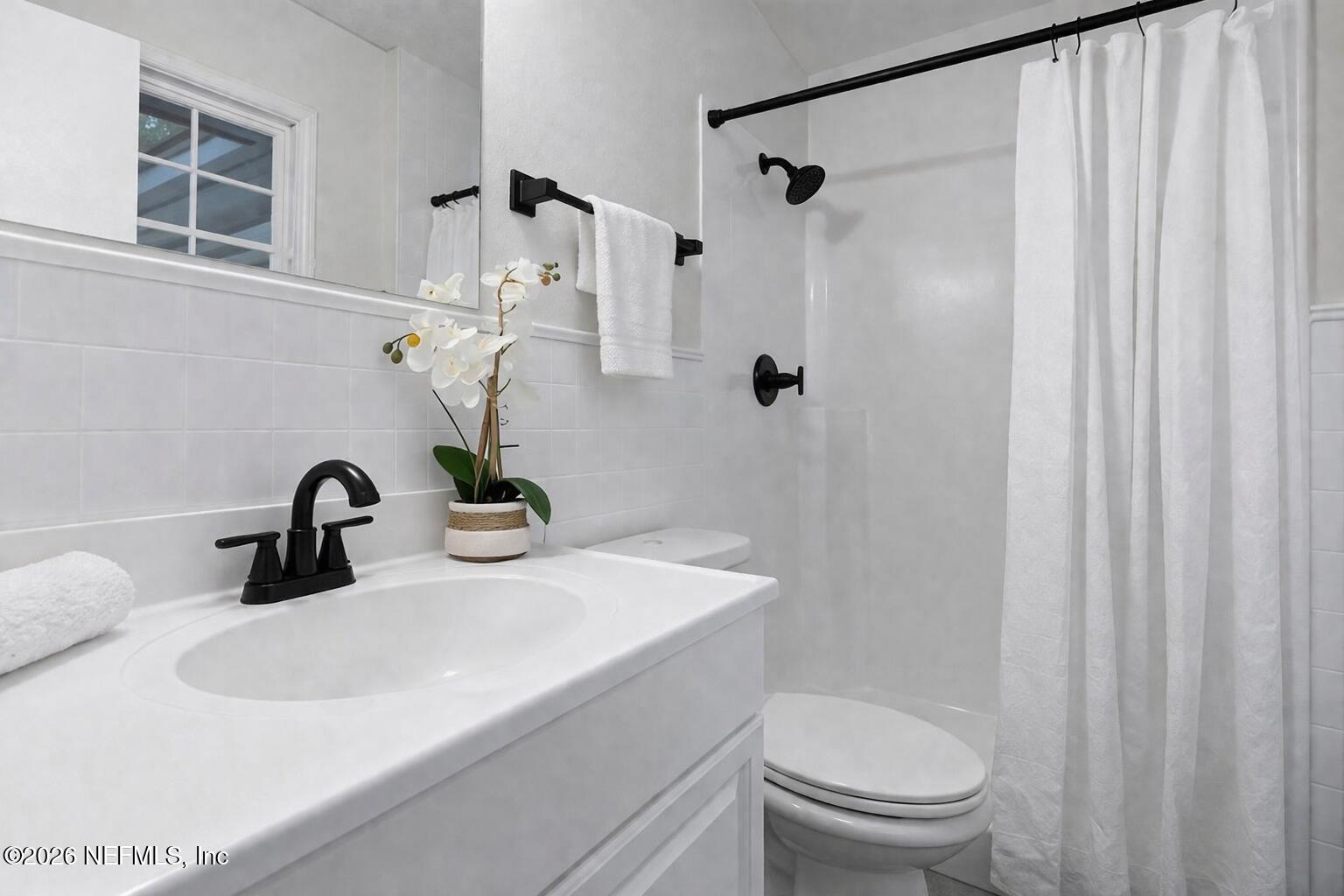 4634 Whimbrel Lane Fernandina Beach, FL 32034 - Photo 10 of 42 a bathroom with a sink a toilet and a mirror