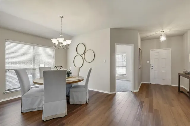 a view of a dining room with furniture a chandelier and wooden floor