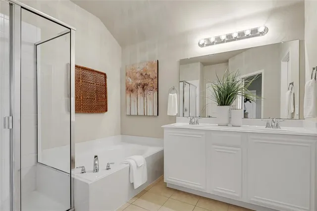a bathroom with a tub a sink and mirror