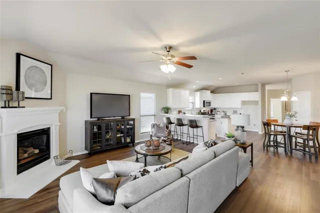 a living room with furniture kitchen view a fireplace and a flat screen tv