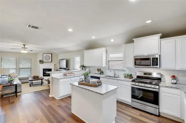 a kitchen with stainless steel appliances a stove sink microwave and cabinets