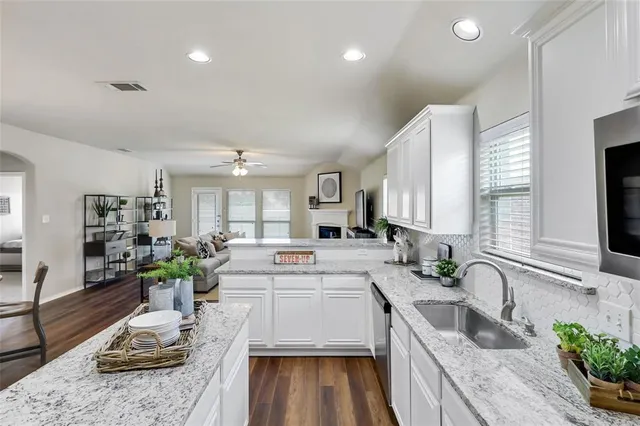 a large white kitchen with a large window and stainless steel appliances