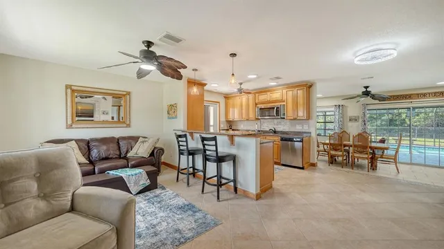a living room with furniture a dining table and chairs with kitchen view